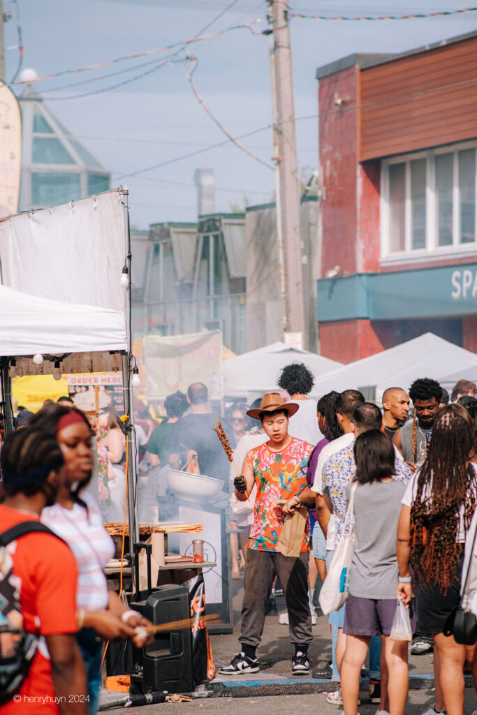 A vendor sells his expertly grilled squid to eager customers at his food stall.