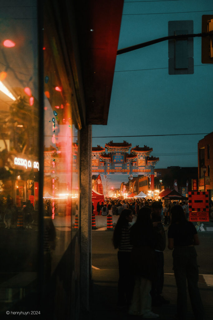 The Ottawa Chinatown Royal Gate reflects beautifully on the window of a Chinese restaurant, adding to the area's charm and allure.